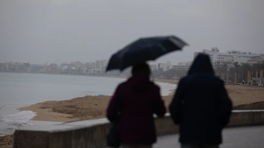 Dos personas caminando bajo la lluvia durante una borrasca en Mallorca Dos personas caminando bajo la lluvia durante una borrasca en Mallorca