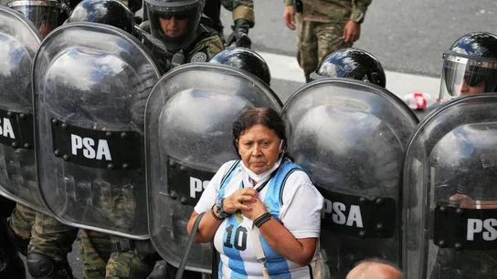 Una mujer ante una línea de agentes policiales durante las protestas de jubilados e hinchas de fútbol en Buenos Aires, este miércoles. Una mujer ante una línea de agentes policiales durante las protestas de jubilados e hinchas de fútbol en Buenos Aires, este miércoles.