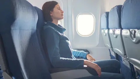 Chica durmiendo en el avión Chica durmiendo en el avión