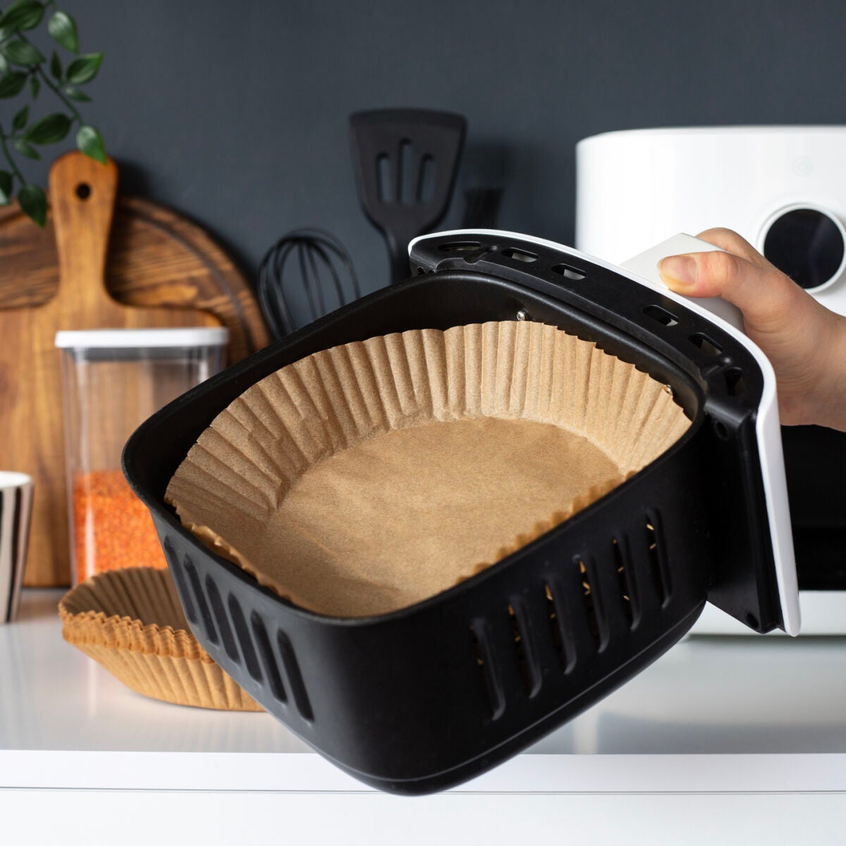 Air fryer basket fitted with a parchment liner