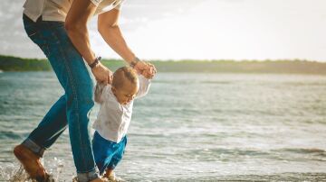 Un padre y su beb&eacute; en la orilla del mar.