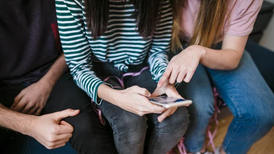 Unas chicas adolescentes con un móvil Móviles y redes sociales