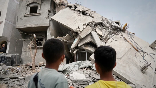 Dos niños observan uno de los edificios derrumbados este domingo por Israel en Jan Yunis. Dos niños observan uno de los edificios derrumbados este domingo por Israel en Jan Yunis.