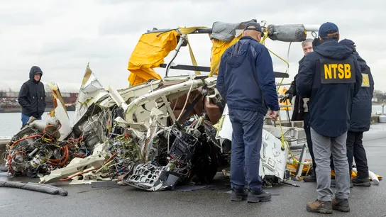 Miembros de la NTSB con una parte rescatada del helicóptero estrellado en el Hudson Miembros de la NTSB con una parte rescatada del helicóptero estrellado en el Hudson