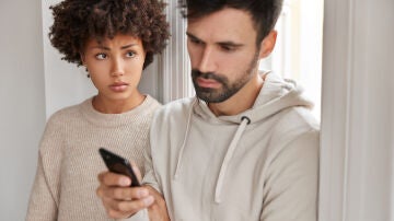 Hombre mirando móvil de su pareja