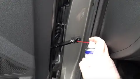 Hombre lubricando una puerta Hombre lubricando una puerta
