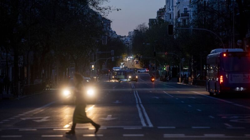 Una mujer y un vehículo tras el apagón eléctrico en Madrid. 