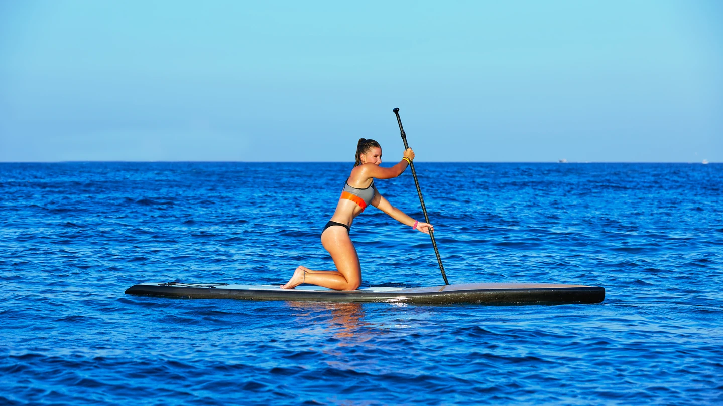 Chica practicando Stand Up Paddle Chica practicando Stand Up Paddle