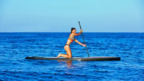 Chica practicando Stand Up Paddle Chica practicando Stand Up Paddle