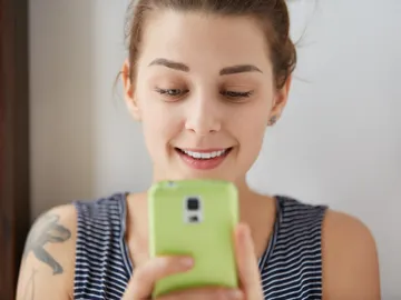 Una mujer consulta el teléfono móvil Una mujer consulta el teléfono móvil