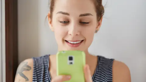 Una mujer consulta el teléfono móvil Una mujer consulta el teléfono móvil