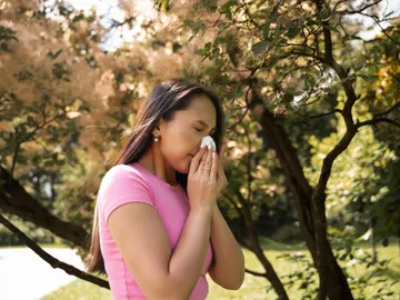 Mujer estornudando por alergia Mujer estornudando por alergia