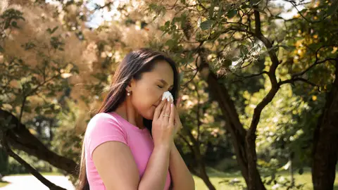 Mujer estornudando por alergia Mujer estornudando por alergia
