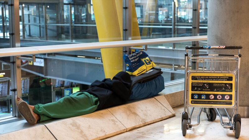 Una persona duerme en la T4 del Aeropuerto Adolfo Suárez-Madrid Barajas, a 12 de mayo de 2025,
