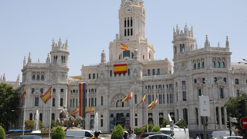 Varias banderas de España y una LGTBI en las inmediaciones del Palacio de Cibeles, sede del Ayuntamiento de Madrid