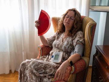 Mujer acalorada tom&aacute;ndose la tensi&oacute;n