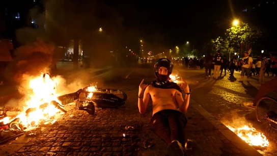 Un objeto arde mientras un joven celebra la Champions del PSG Un objeto arde mientras un joven celebra la Champions del PSG