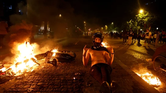 Un joven, celebrando el título del PSG al lado de un objeto ardiendo Un joven, celebrando el título del PSG al lado de un objeto ardiendo