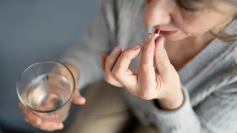 Mujer tomando un medicamento Mujer tomando un medicamento