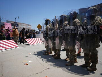 Un grupo de manifestantes frente a miembros de la Guardia Nacional en Los Ángeles, este domingo.