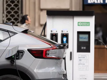 Un coche cargándose en un punto de recarga público Un coche cargándose en un punto de recarga público