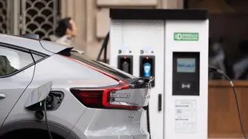 Un coche cargándose en un punto de recarga público Un coche cargándose en un punto de recarga público