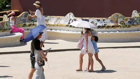Varias personas se protegen del sol con paraguas Varias personas se protegen del sol con paraguas