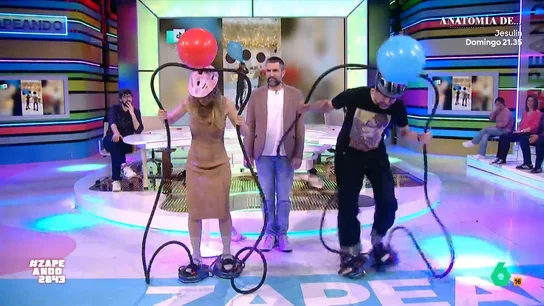 María Gómez y Nacho García se enfrentan en un divertido juego: "Tenemos una pinta estupenda" Los zapeadores deben explotar un globo, que tienen enganchado en su cabeza. Pero, para ello, deben utilizar unas bombas de aire que están enganchadas en sus pies. No te pierdas su hilarante 'competición' en el vídeo principal.