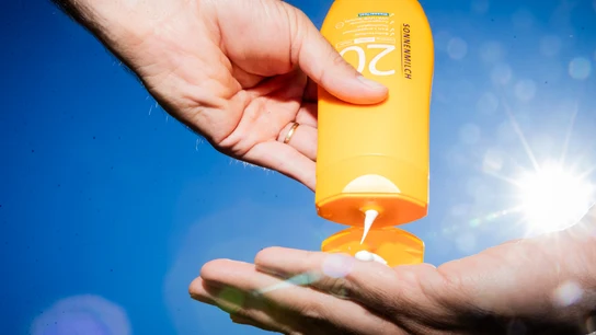 Un hombre echándose crema solar factor 20 Un hombre echándose crema solar factor 20