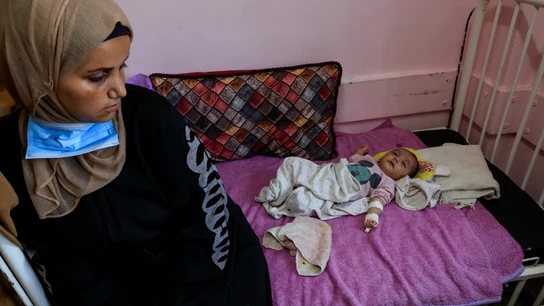 Una mujer palestina con su hijo, infectado con meningitis, en el Hospital Nasser en Jan Younis, Gaza. Una mujer palestina con su hijo, infectado con meningitis, en el Hospital Nasser en Jan Younis, Gaza.