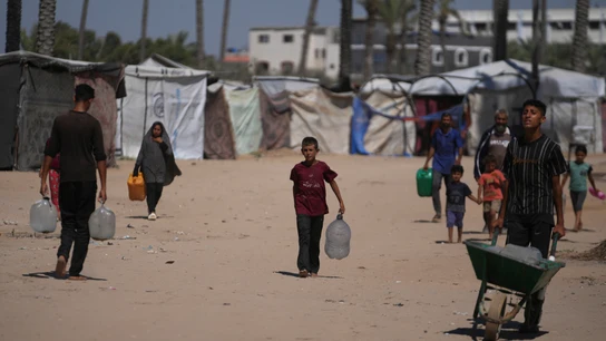 Palestinos llevan contenedores de agua en un campamento para desplazados en Deir al-Balah, Franja de Gaza, el lunes 7 de julio de 2025. Palestinos llevan contenedores de agua en un campamento para desplazados en Deir al-Balah, Franja de Gaza, el lunes 7 de julio de 2025.