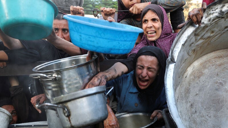 Palestinos esperan recibir comida de un comedor social, en la ciudad de Gaza.