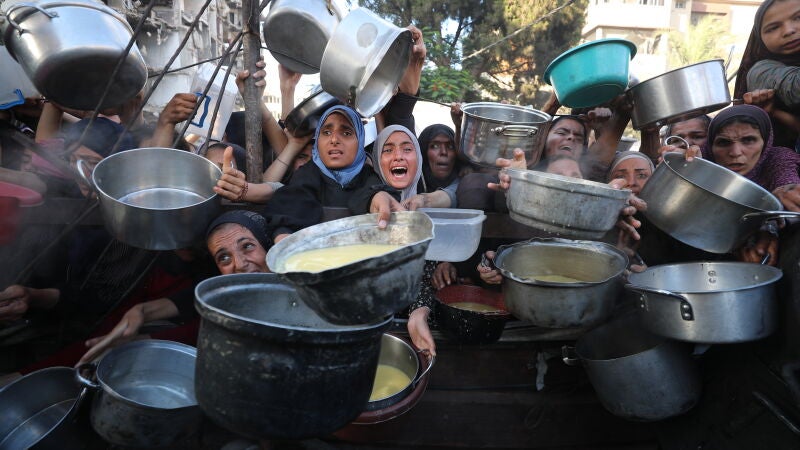 Decenas de palestinos, tratando de recibir alimentos en un punto de recogida de Gaza