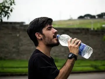 Un hombre bebiendo agua Un hombre bebiendo agua