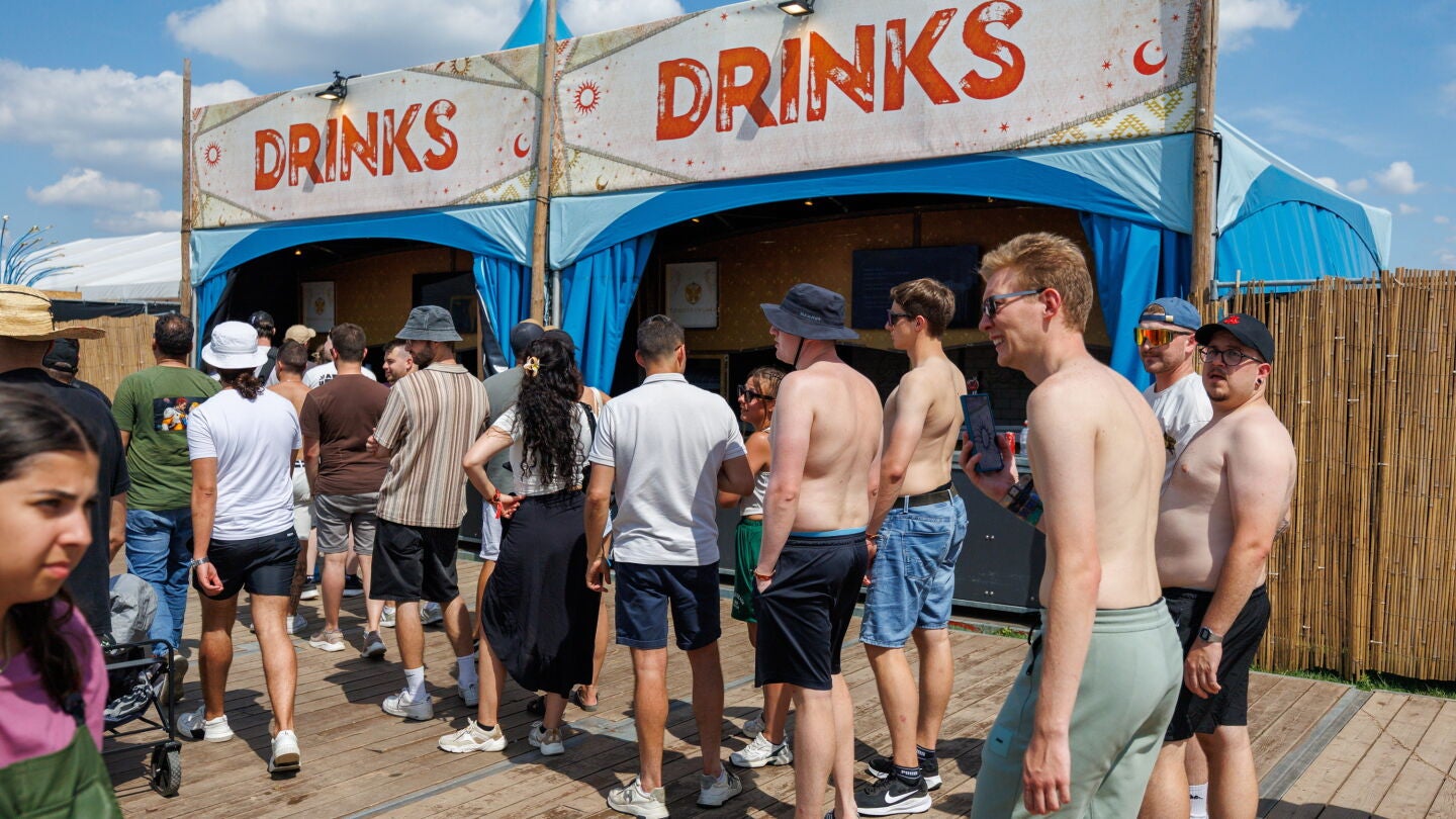 Varios asistentes al festival Tomorrowland 2025, haciendo cola para comprar bebidas en el camping