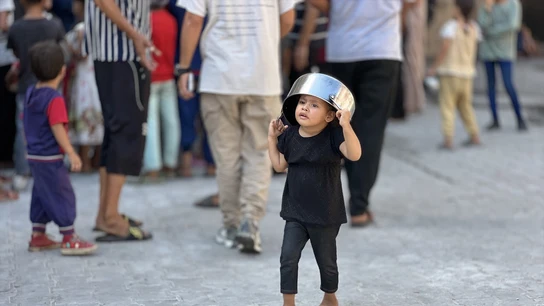 Un niño palestino espera frente a un punto de distribución gratuita de alimentos para recibir su ración de comida caliente en el campo de refugiados de Nusairat, en el centro de la Franja de Gaza Un niño palestino espera frente a un punto de distribución gratuita de alimentos para recibir su ración de comida caliente en el campo de refugiados de Nusairat, en el centro de la Franja de Gaza