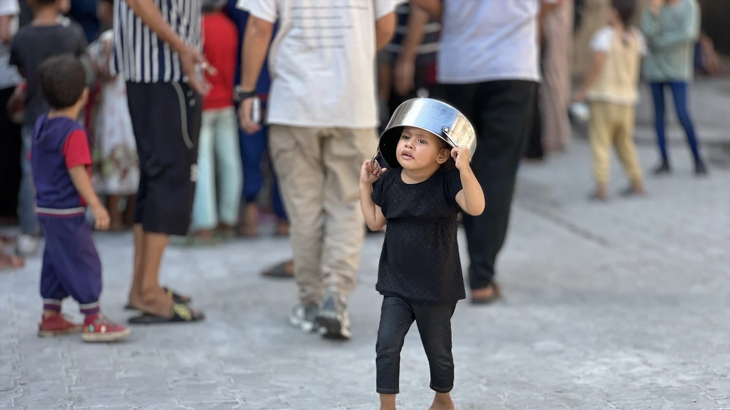 Un niño palestino espera frente a un punto de distribución gratuita de alimentos para recibir su ración de comida caliente en el campo de refugiados de Nusairat, en el centro de la Franja de Gaza Un niño palestino espera frente a un punto de distribución gratuita de alimentos para recibir su ración de comida caliente en el campo de refugiados de Nusairat, en el centro de la Franja de Gaza