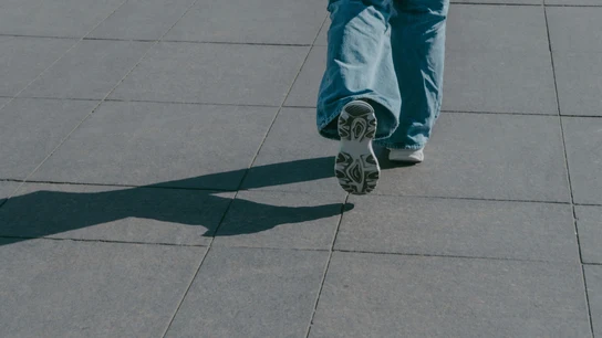 Una persona caminando sobre el asfalto Una persona caminando sobre el asfalto