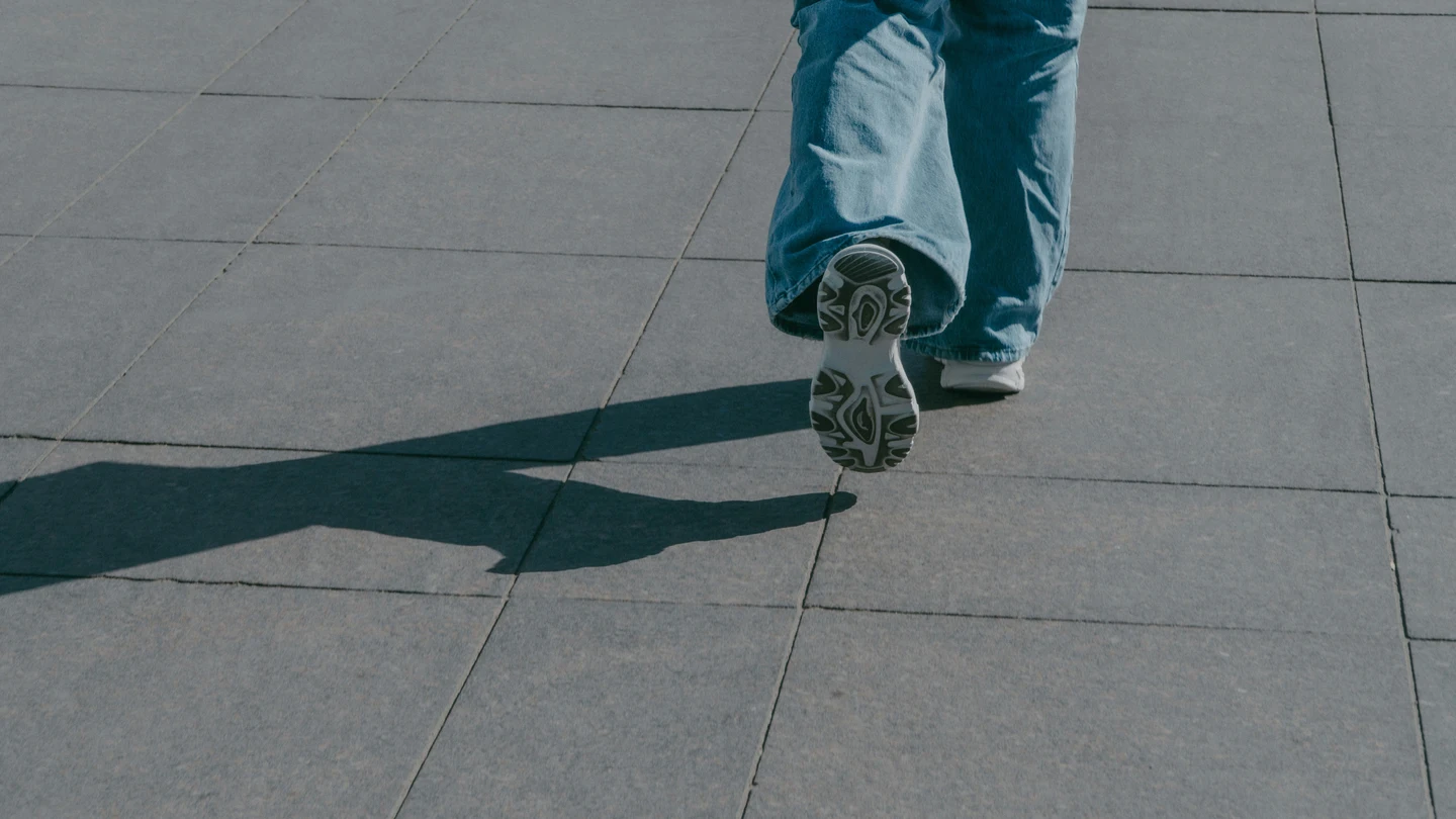 Una persona caminando sobre el asfalto Una persona caminando sobre el asfalto