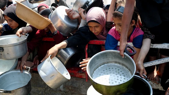 Palestinos esperan a recibir comida en Gaza. Palestinos esperan a recibir comida en Gaza.