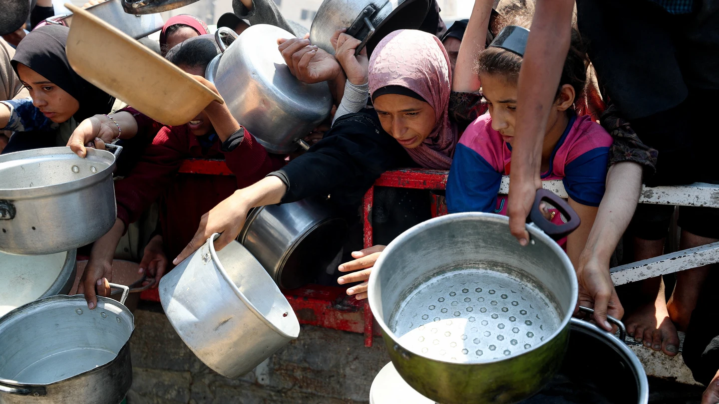 Palestinos esperan a recibir comida en Gaza. Palestinos esperan a recibir comida en Gaza.