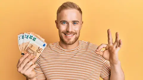 Chico sujetando dinero en efectivo Chico sujetando dinero en efectivo