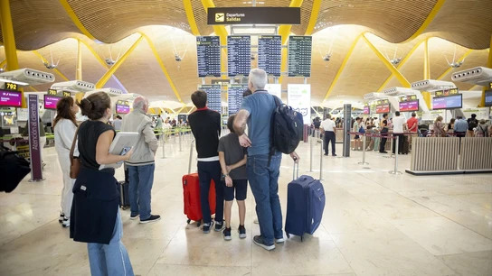 Viajeros esperan sus vuelos para comenzar las vacaciones. Viajeros esperan sus vuelos para comenzar las vacaciones.