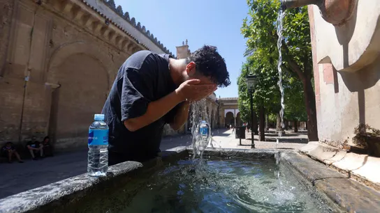 Un hombre trata de refrescarse en una fuente Un hombre trata de refrescarse en una fuente