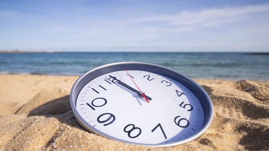 Reloj sobre la arena de una playa Reloj sobre la arena de una playa