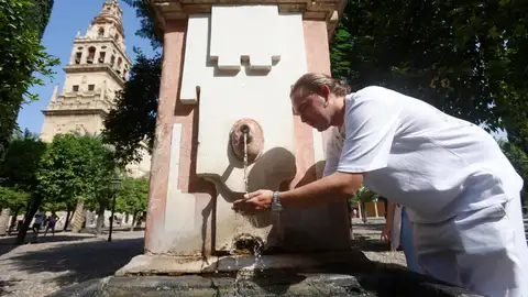 Imagen de archivo. Una persona se refresca en una fuente. Imagen de archivo. Una persona se refresca en una fuente.