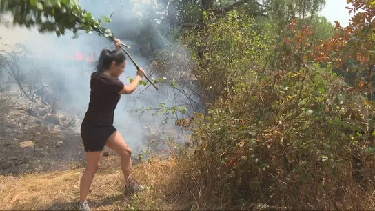 Una vecina intenta apagar el fuego con una rama Una vecina intenta apagar el fuego con una rama