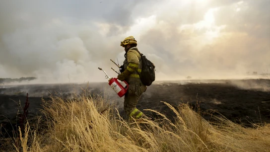 Un bombero tratando de extinguir el incendio. Un bombero tratando de extinguir el incendio.