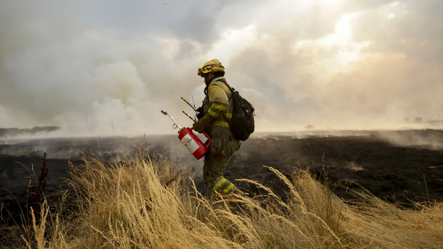 Un bombero tratando de extinguir el incendio. Un bombero tratando de extinguir el incendio.