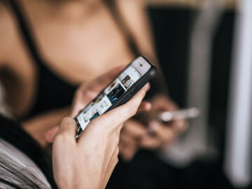 Imagen de una mujer mirando el m&oacute;vil